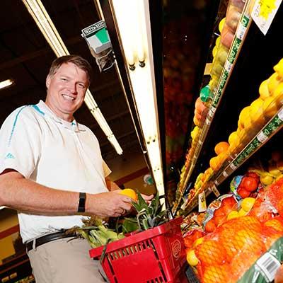 Todd Bartee picking fruit from a shelf
