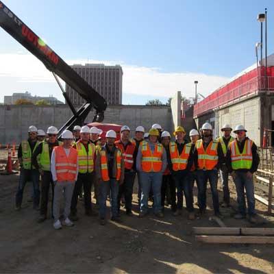 construction management students pose for a picture on a job site tour